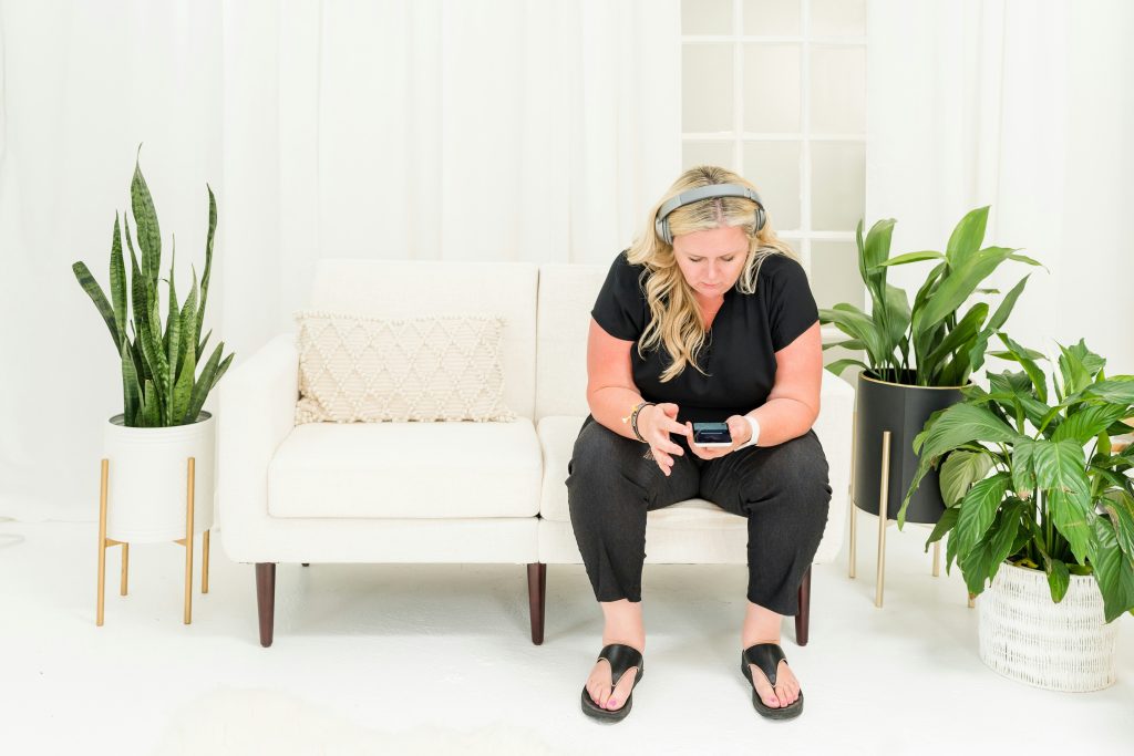 Een vrouw zit op een bank en luistert muziek