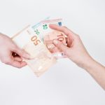 Twee mensen wisselen eurobiljetten uit