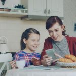 Mama en dochter kijken op een smartphone